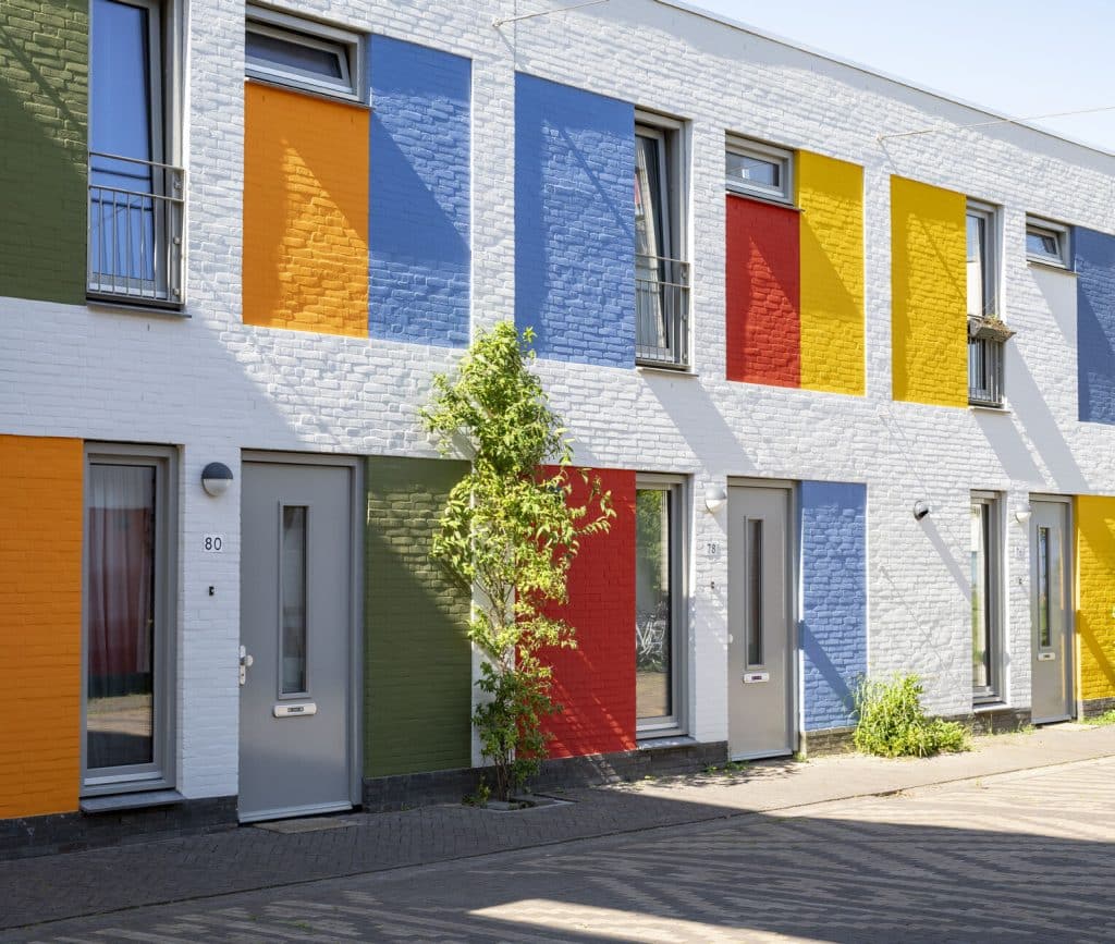 Witte gevels met kleurvlakken in oranje, blauw, rood en geel in Woensel-West
