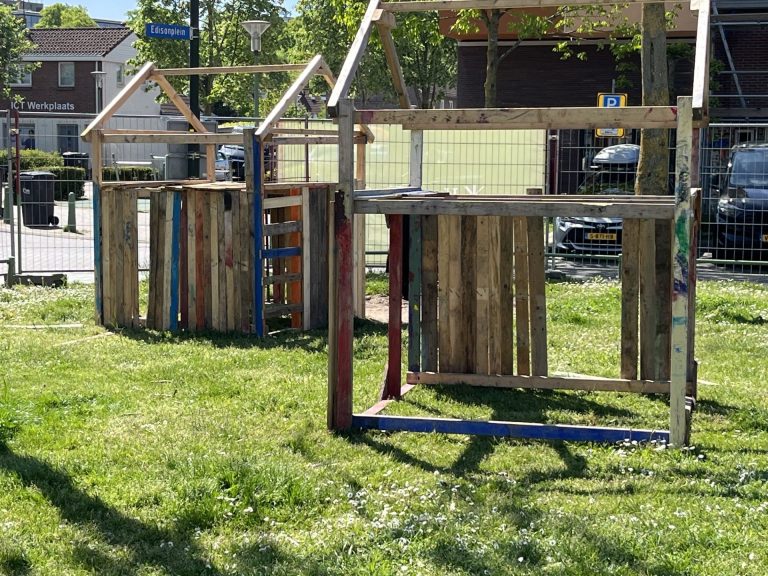Kinderen timmeren huisjes van pallets
